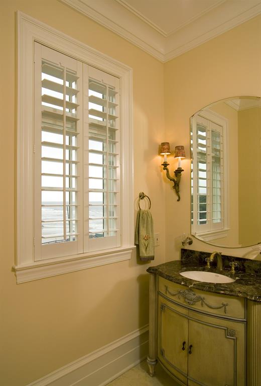 White shutters in a bathroom outlooking the ocean